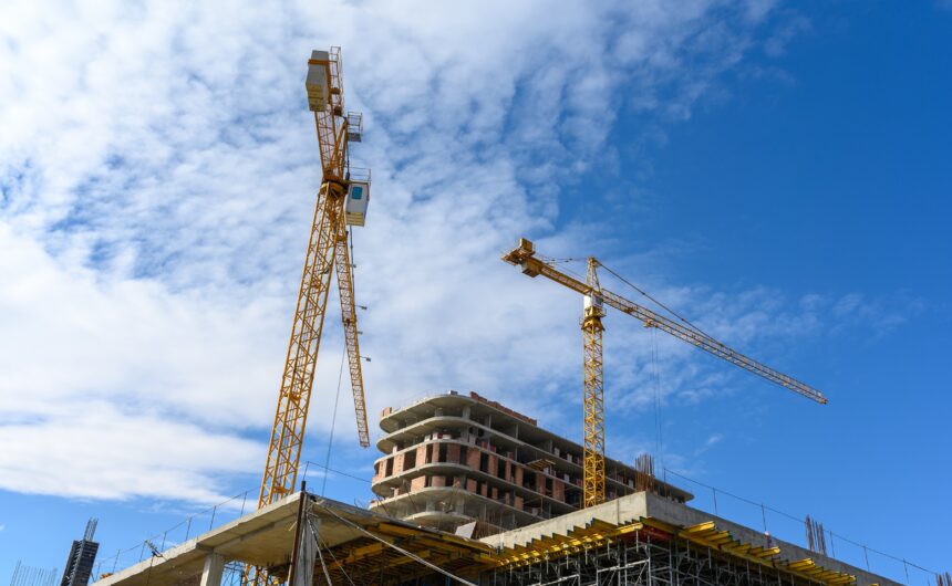 Crane and building construction site against blue sky Un projecte emprarà intel·ligència artificial, robòtica, sensors virtuals i ciberseguretat per aconseguir una construcció sense accidents